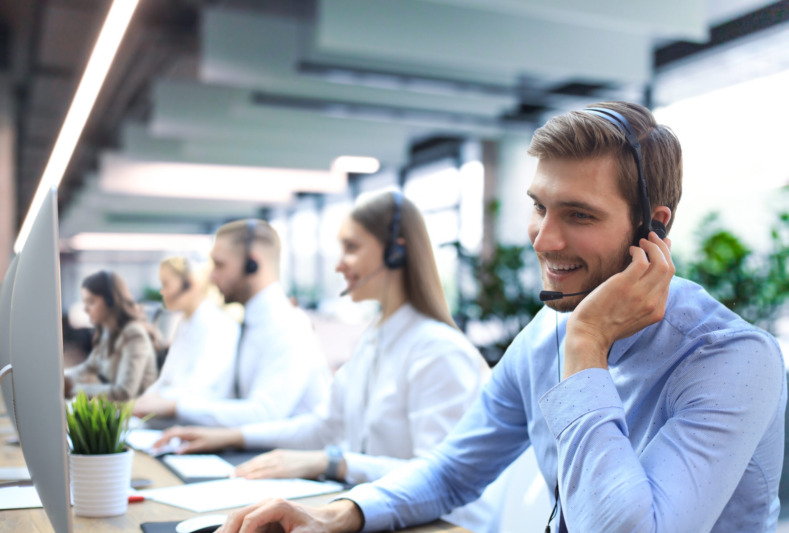 Portrait,Of,Call,Center,Worker,Accompanied,By,His,Team.,Smiling